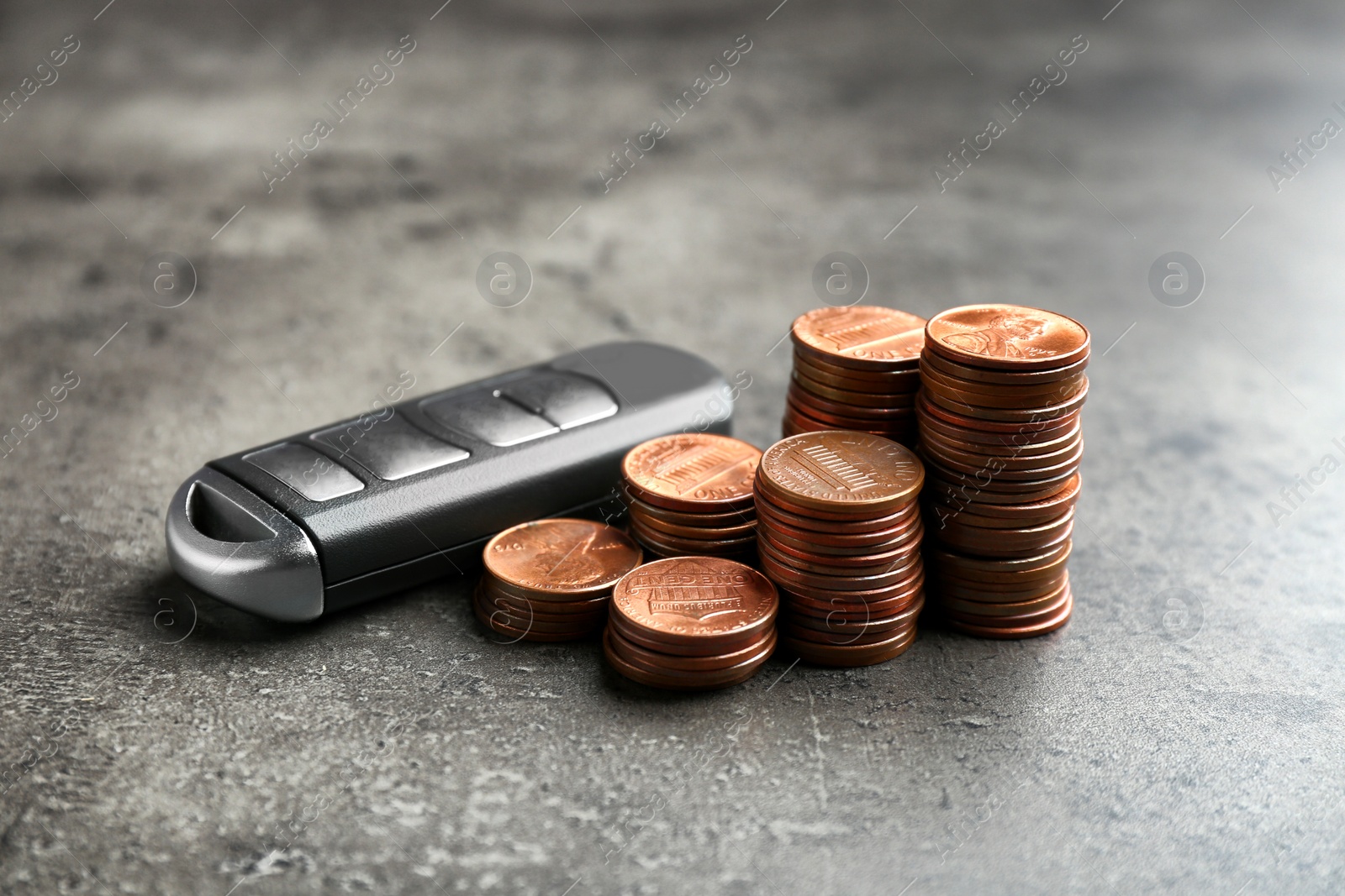 Photo of Car alarm key and coins on grey background