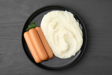 Photo of Delicious boiled sausages, mashed potato and parsley on grey wooden table, top view