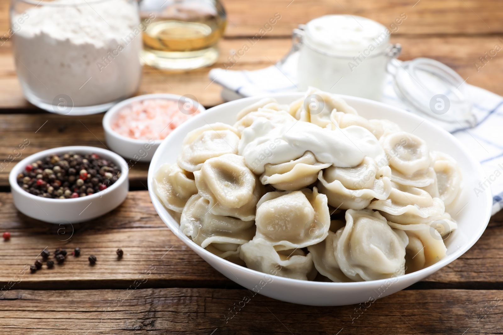 Photo of Tasty dumplings in bowl on wooden table