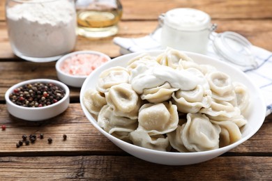 Photo of Tasty dumplings in bowl on wooden table