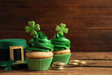 Composition with delicious decorated cupcakes on wooden table, space for text. St. Patrick's Day celebration