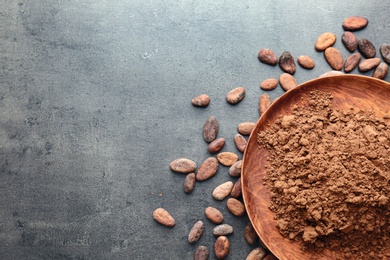 Flat lay composition with cocoa powder and beans on grey background