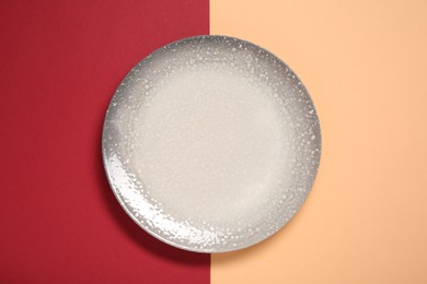 Photo of One ceramic plate on color background, top view