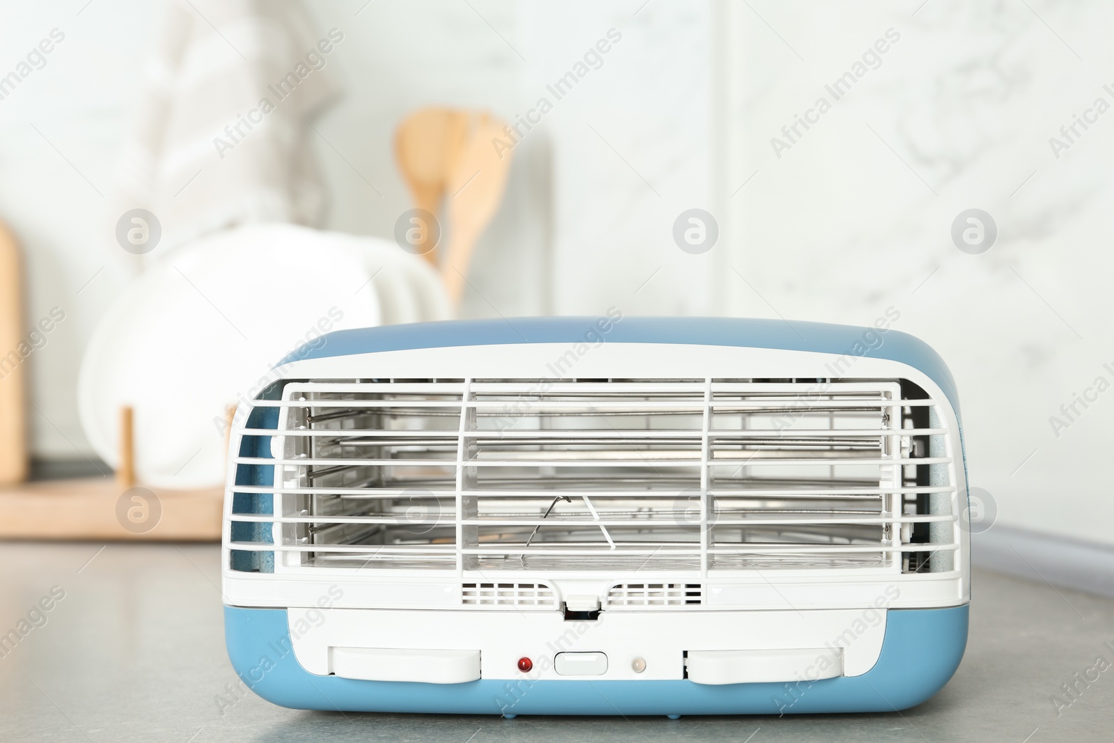 Photo of Stylish ionic air purifier in kitchen. Modern interior element