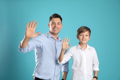 Portrait of dad and his son on color background