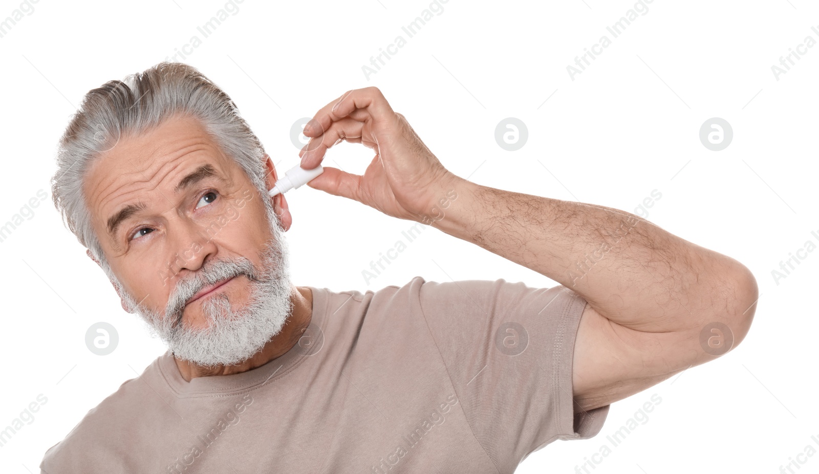 Photo of Senior man using ear drops on white background