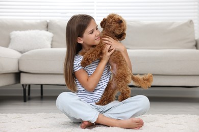 Little child with cute puppy on carpet at home. Lovely pet