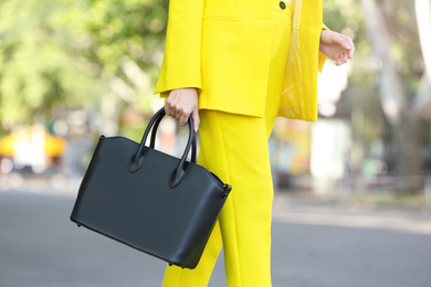 Young woman with stylish leather bag outdoors on summer day, closeup