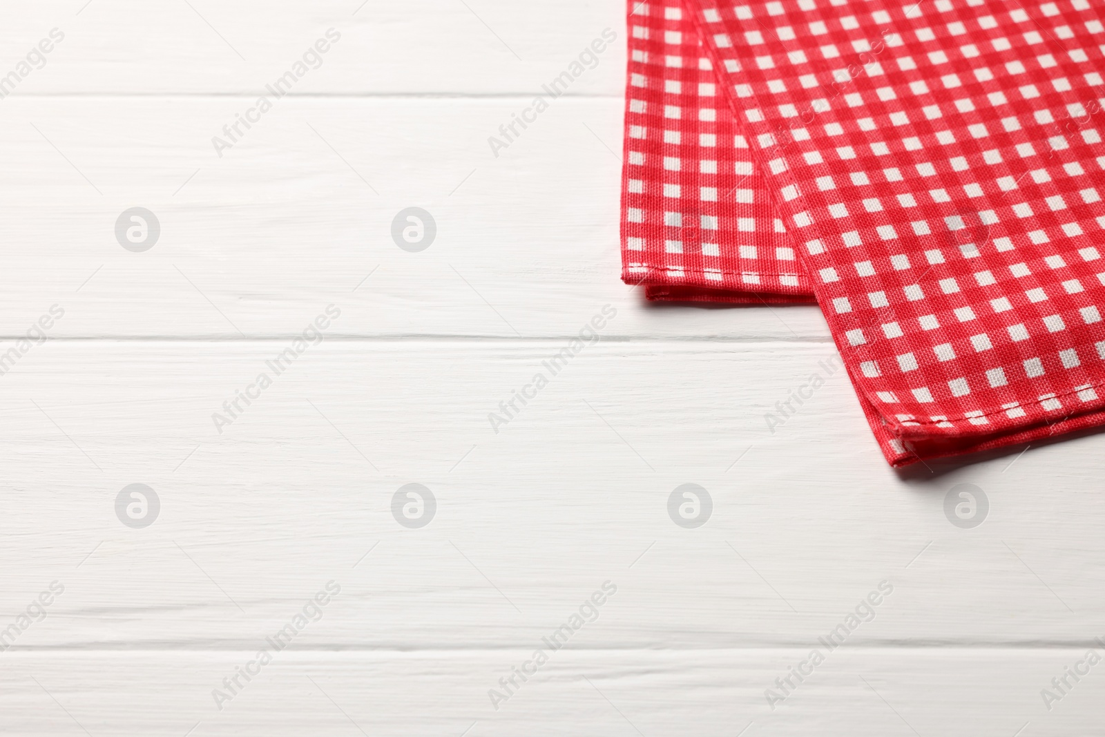 Photo of Red checkered tablecloth on wooden table, space for text