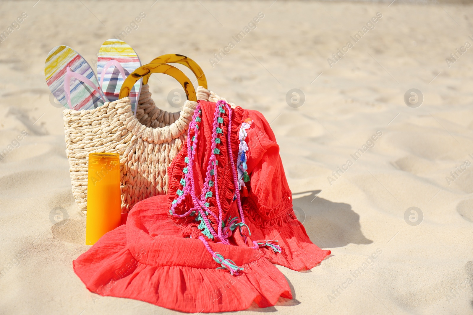 Photo of Set with stylish beach accessories on sand. Space for text