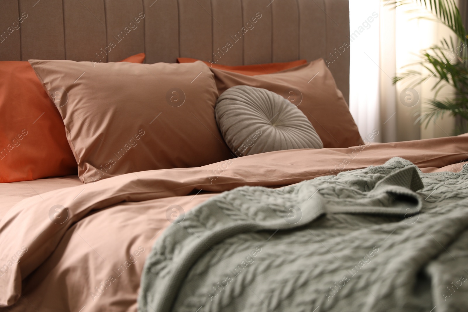 Photo of Bed with stylish cotton linens in room