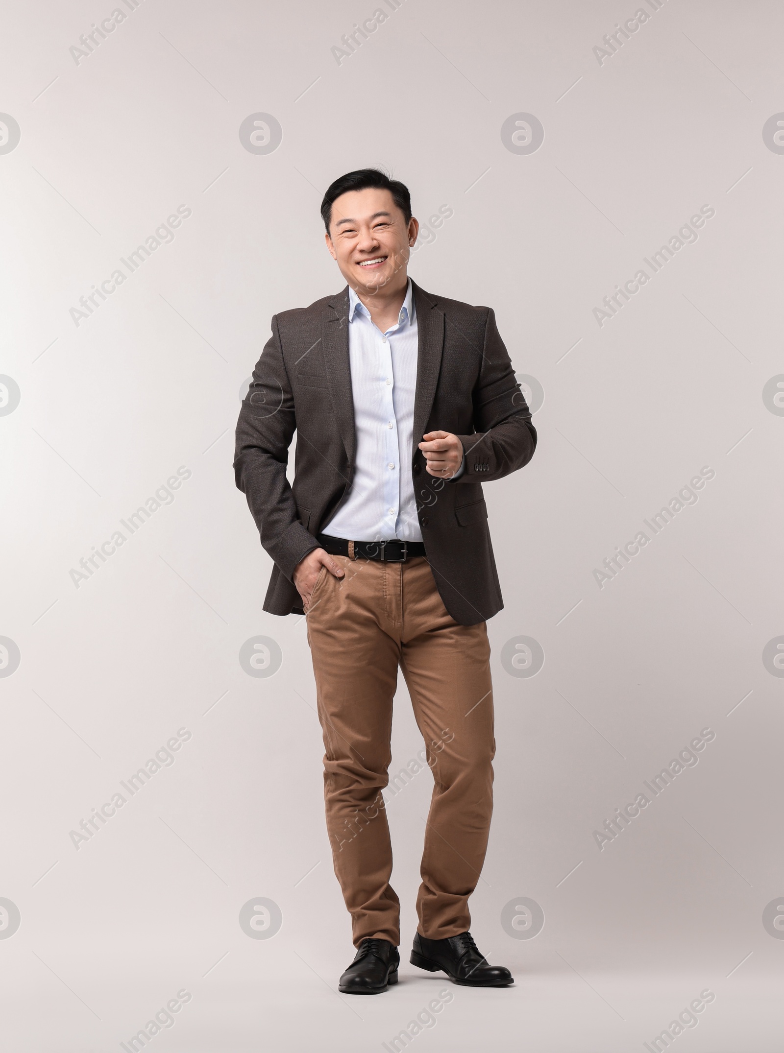Photo of Full length portrait of happy man on light background. Space for text