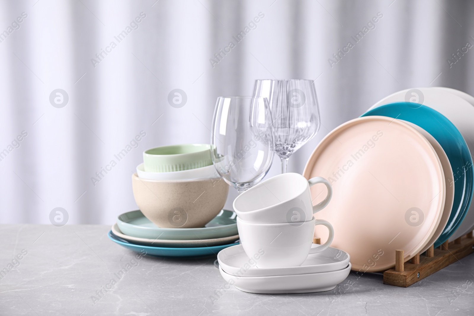 Photo of Set of clean dishware on marble table