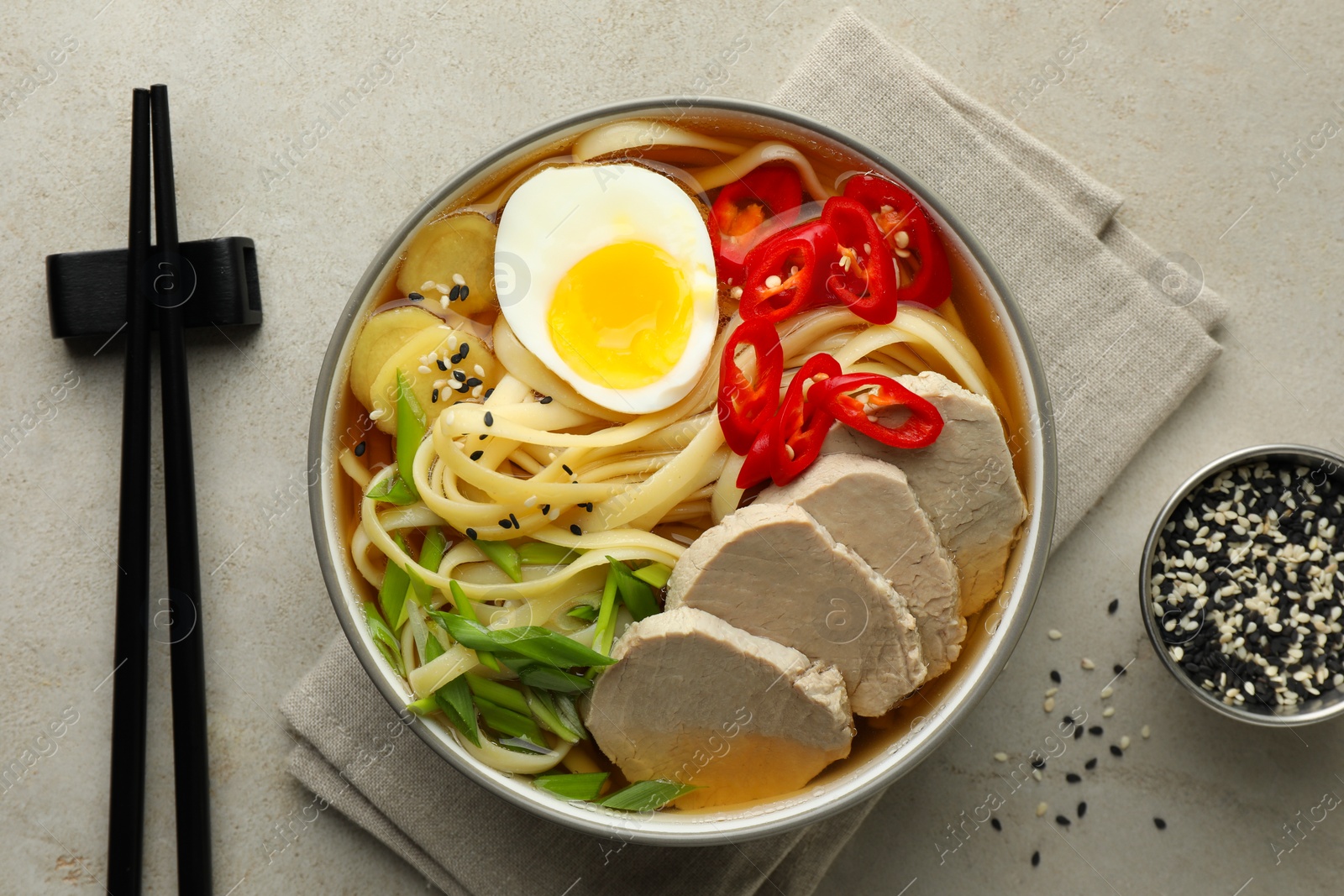 Photo of Delicious ramen in bowl served on light textured table, flat lay. Noodle soup