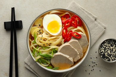 Photo of Delicious ramen in bowl served on light textured table, flat lay. Noodle soup