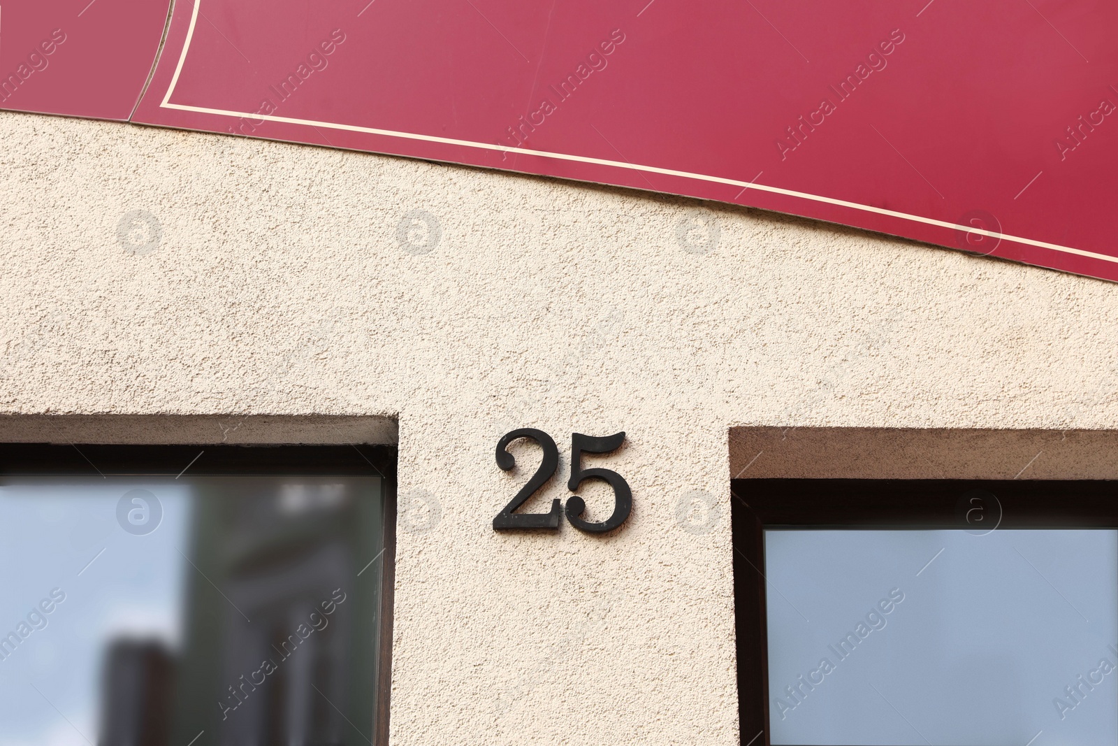 Photo of House number 25 on beige building outdoors