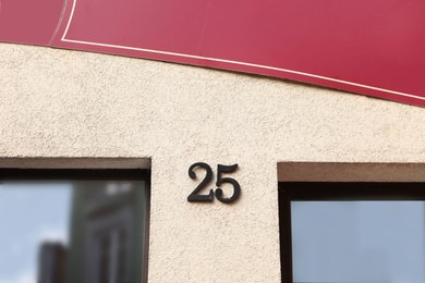 House number 25 on beige building outdoors