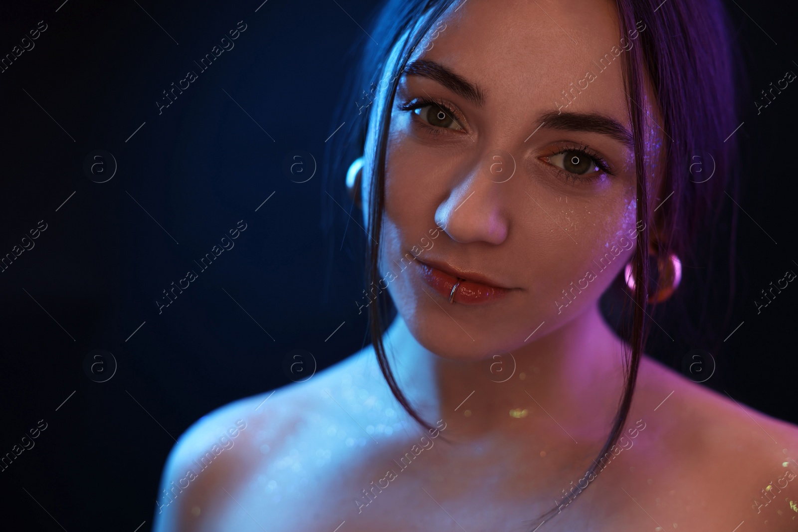 Photo of Portrait of beautiful woman on dark background in neon lights