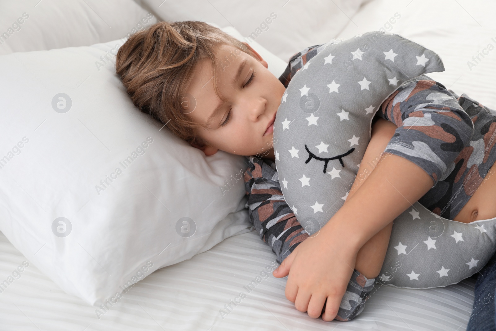 Photo of Cute boy with toy sleeping in bed