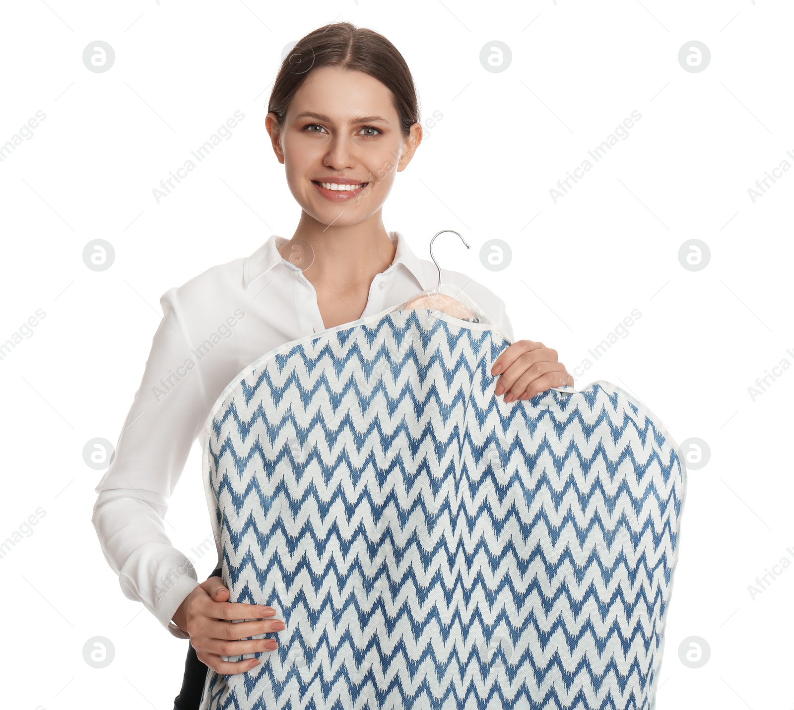 Photo of Young woman holding hanger with clothes in garment cover on white background. Dry-cleaning service