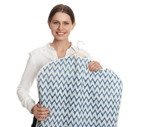 Young woman holding hanger with clothes in garment cover on white background. Dry-cleaning service