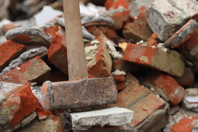 Sledgehammer on pile of broken bricks, closeup