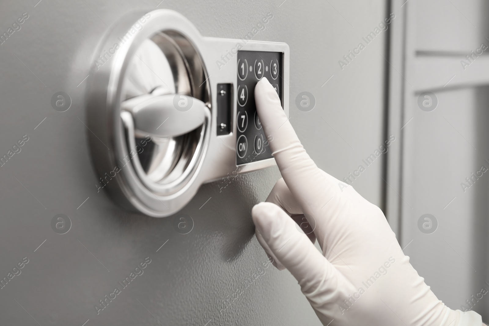 Photo of Woman in gloves entering code on keypad of modern safe, closeup