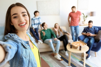 Photo of Happy friends taking selfie indoors