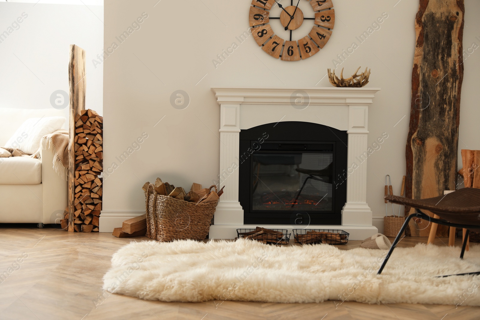 Photo of Beautiful fireplace and basket with firewood in contemporary room interior