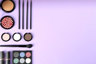 Photo of Flat lay composition with makeup brushes on violet background, space for text