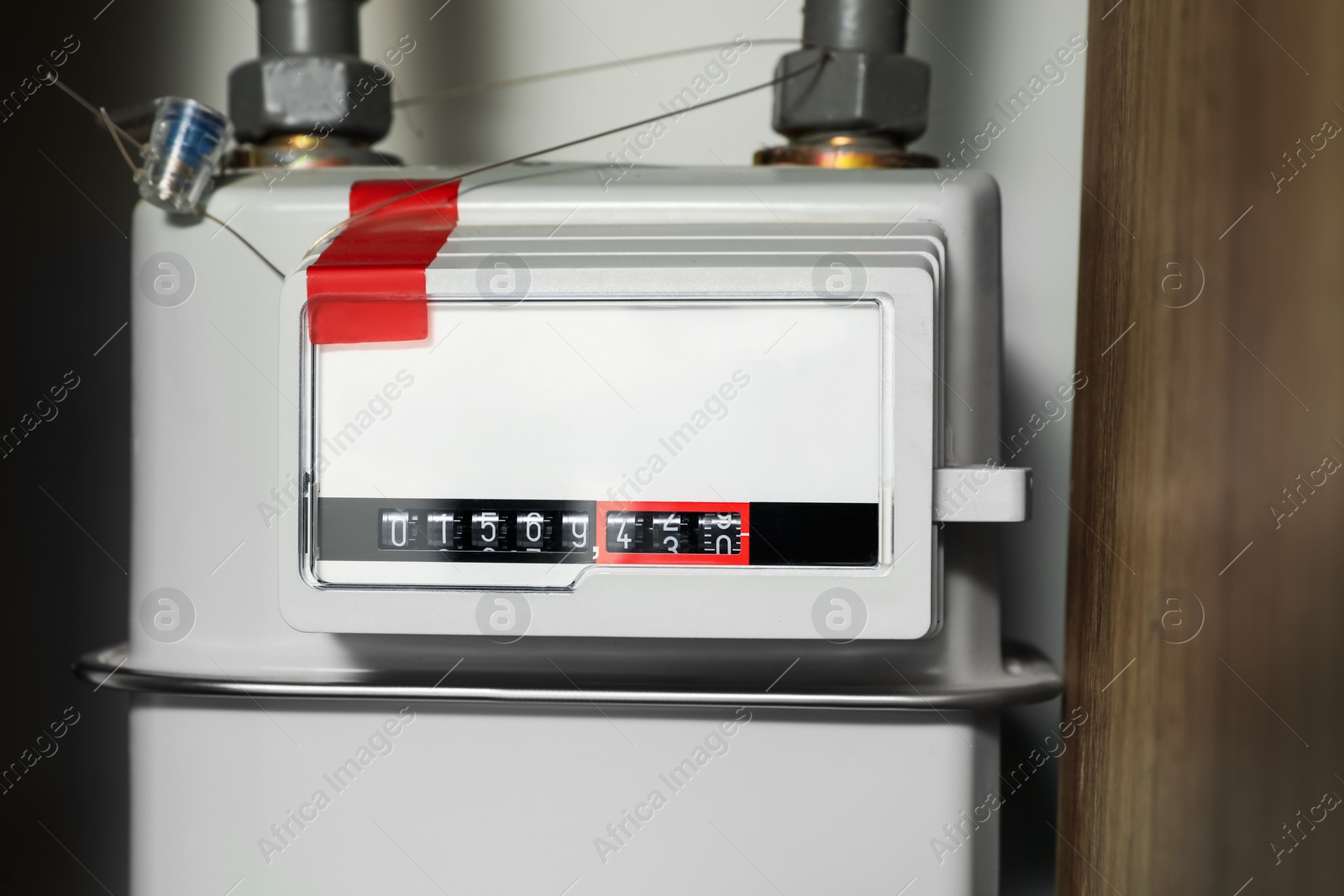 Photo of Electric meter near white wall, closeup. Gas measuring device