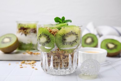 Delicious dessert with kiwi and muesli on white table, closeup