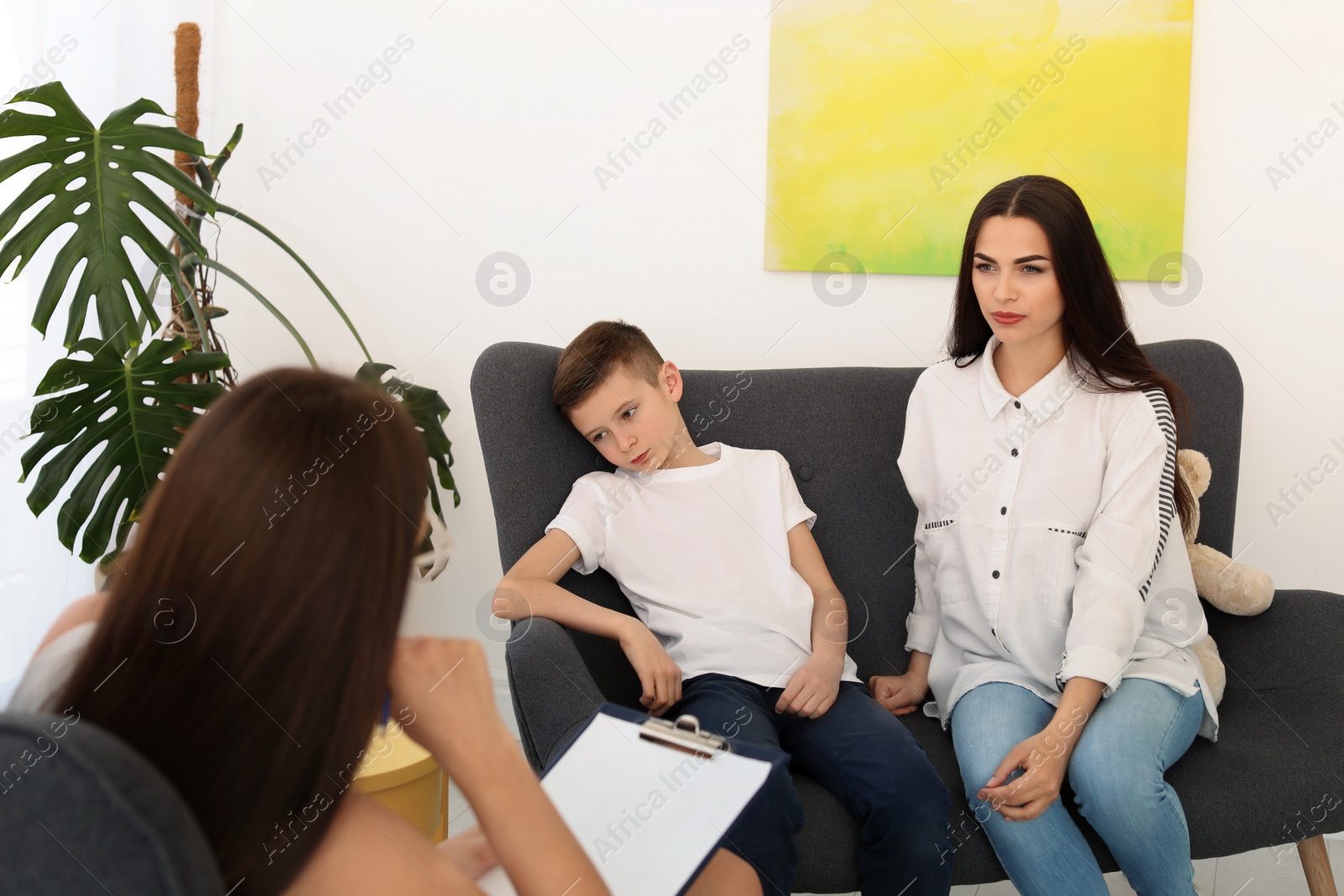 Photo of Young woman and her son having appointment with child psychologist in office