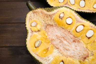 Delicious cut exotic jackfruit on wooden table, flat lay