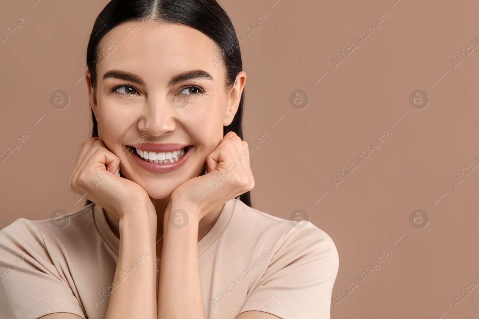 Photo of Beautiful woman with clean teeth smiling on beige background, space for text