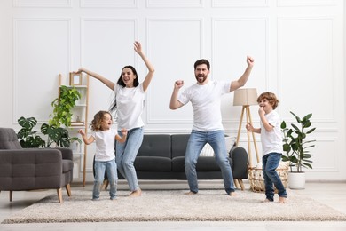 Photo of Happy family dancing and having fun in living room