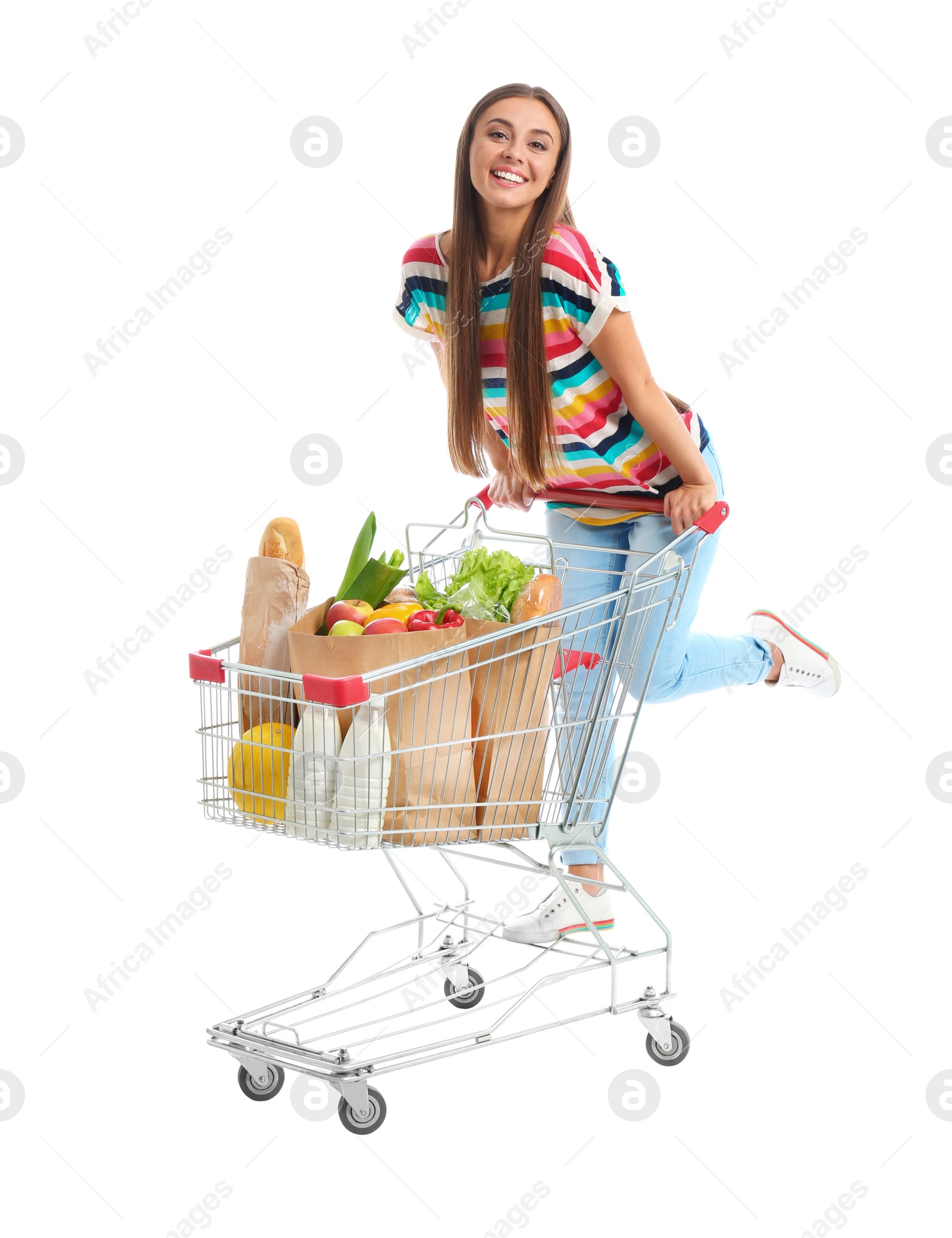 Photo of Young woman with full shopping cart on white background