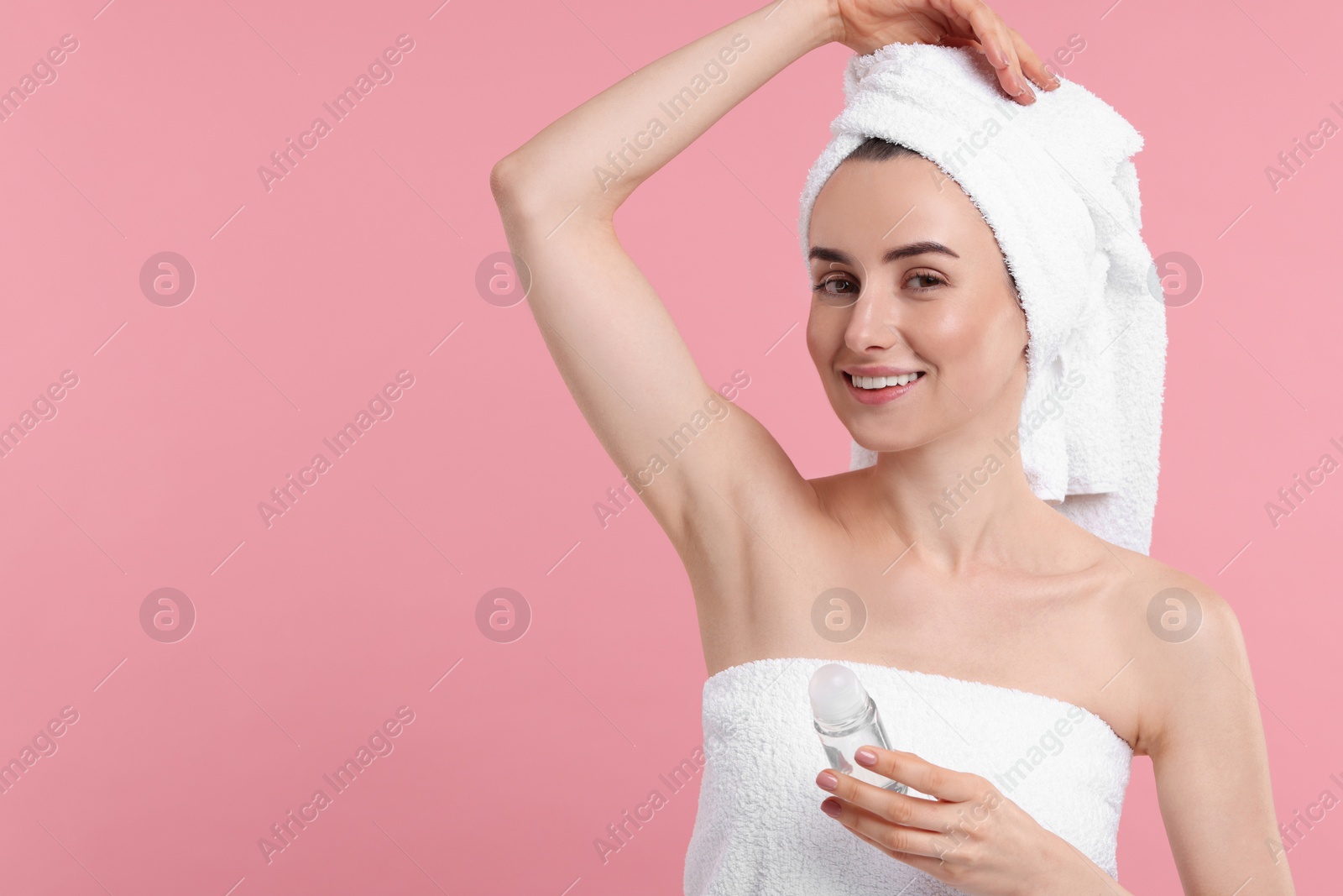 Photo of Beautiful woman applying deodorant on pink background, space for text