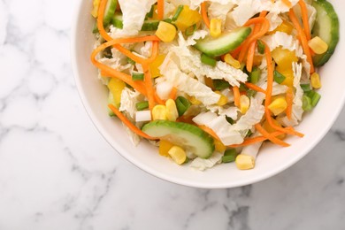 Tasty salad with Chinese cabbage, carrot, corn and cucumber in bowl on white marble table, top view