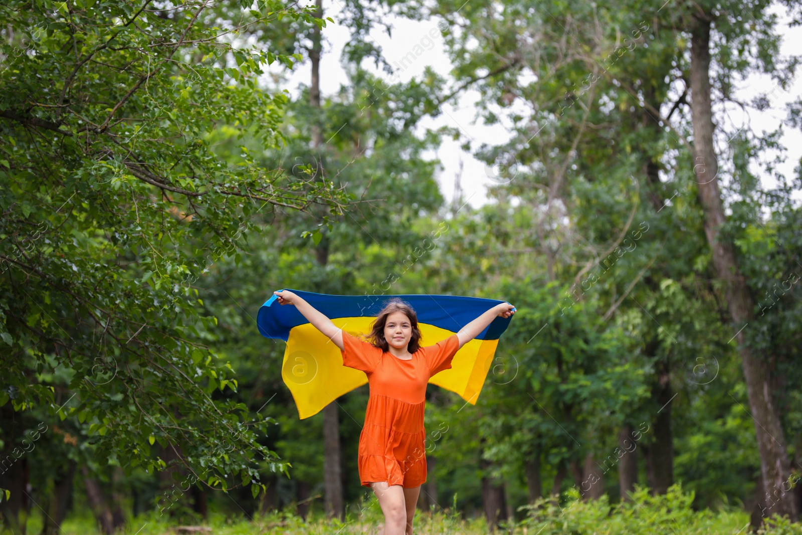 Photo of Teenage girl with flag of Ukraine outdoors