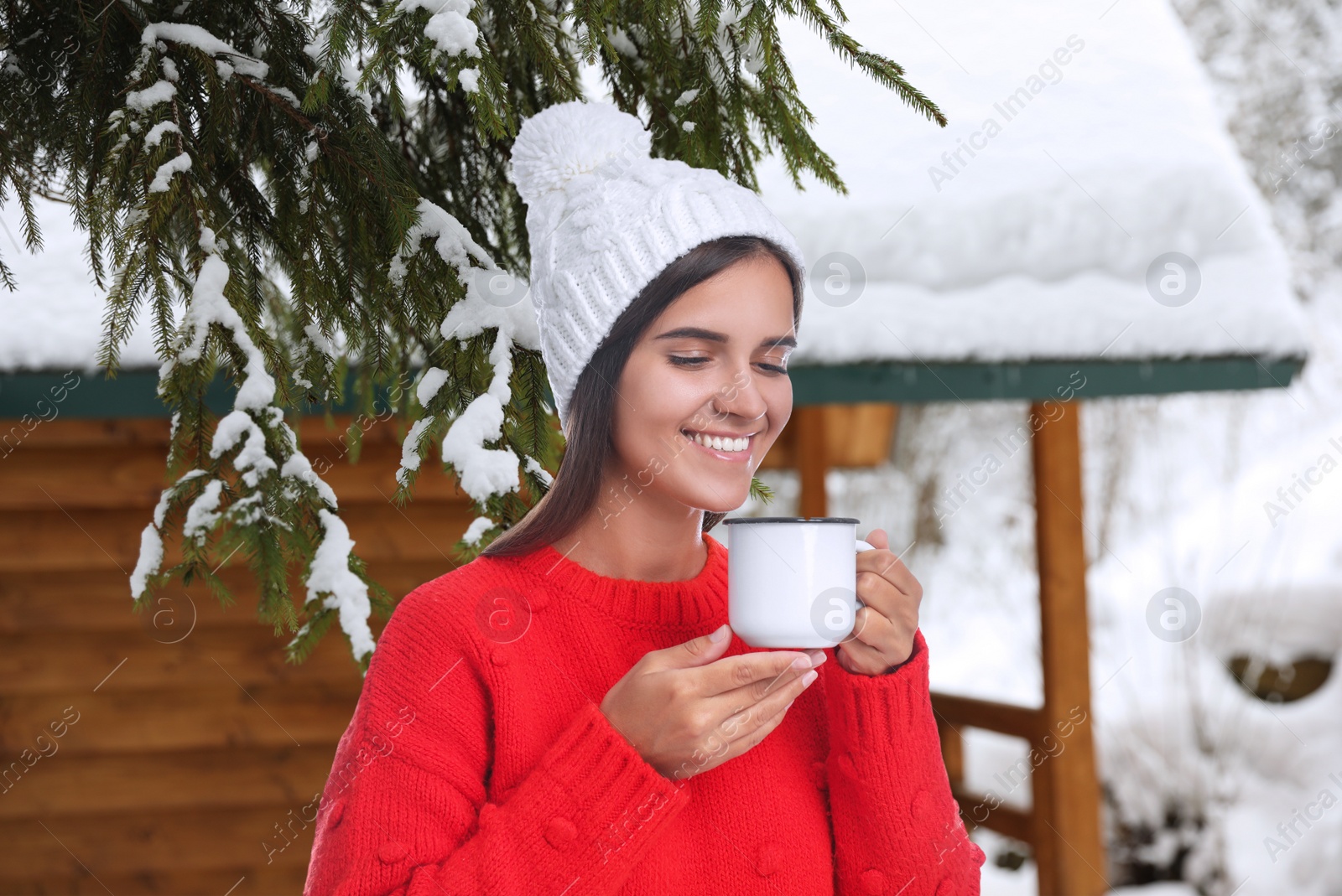 Image of Happy beautiful woman with mulled wine outdoors on snowy day 