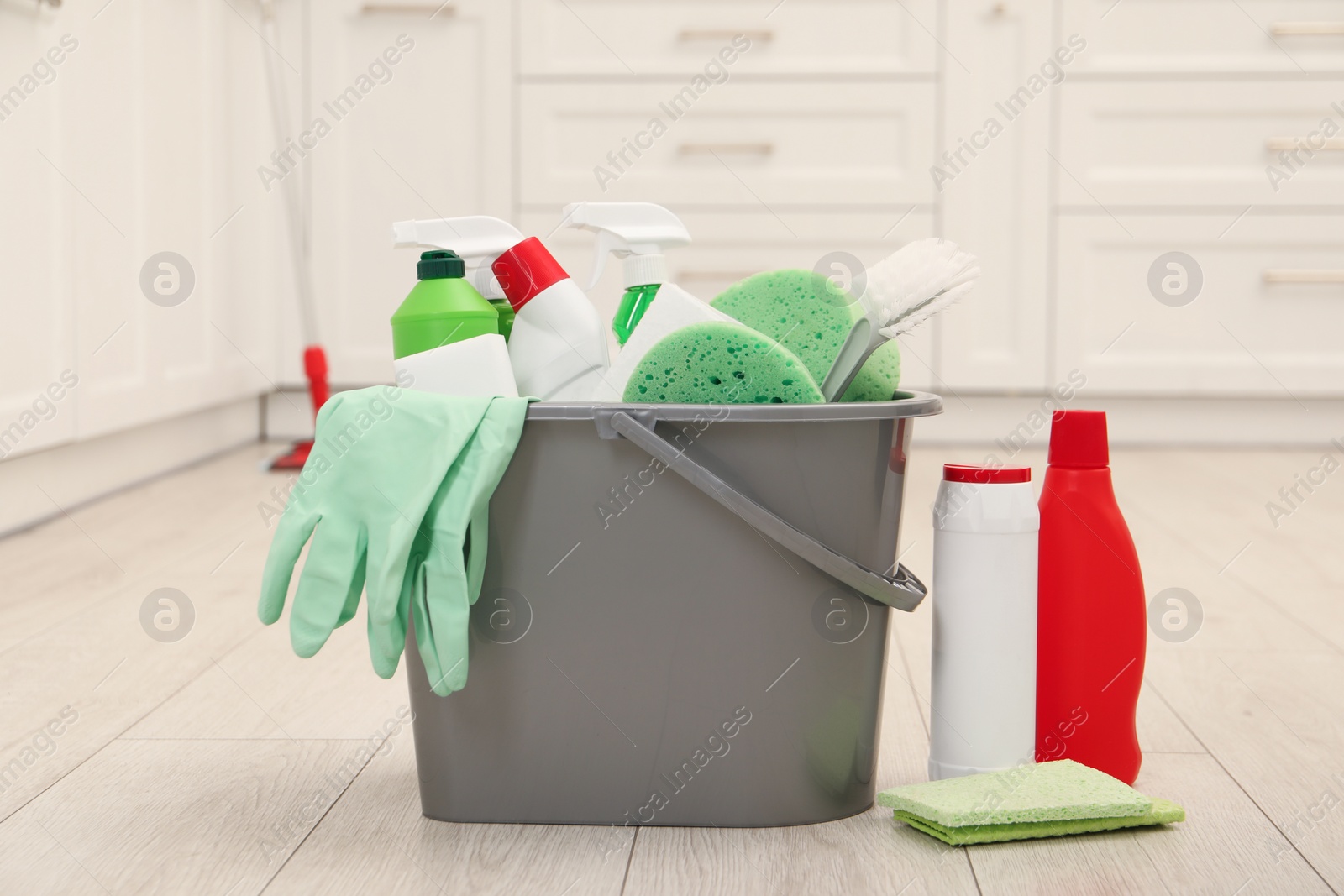 Photo of Different cleaning supplies in bucket on floor