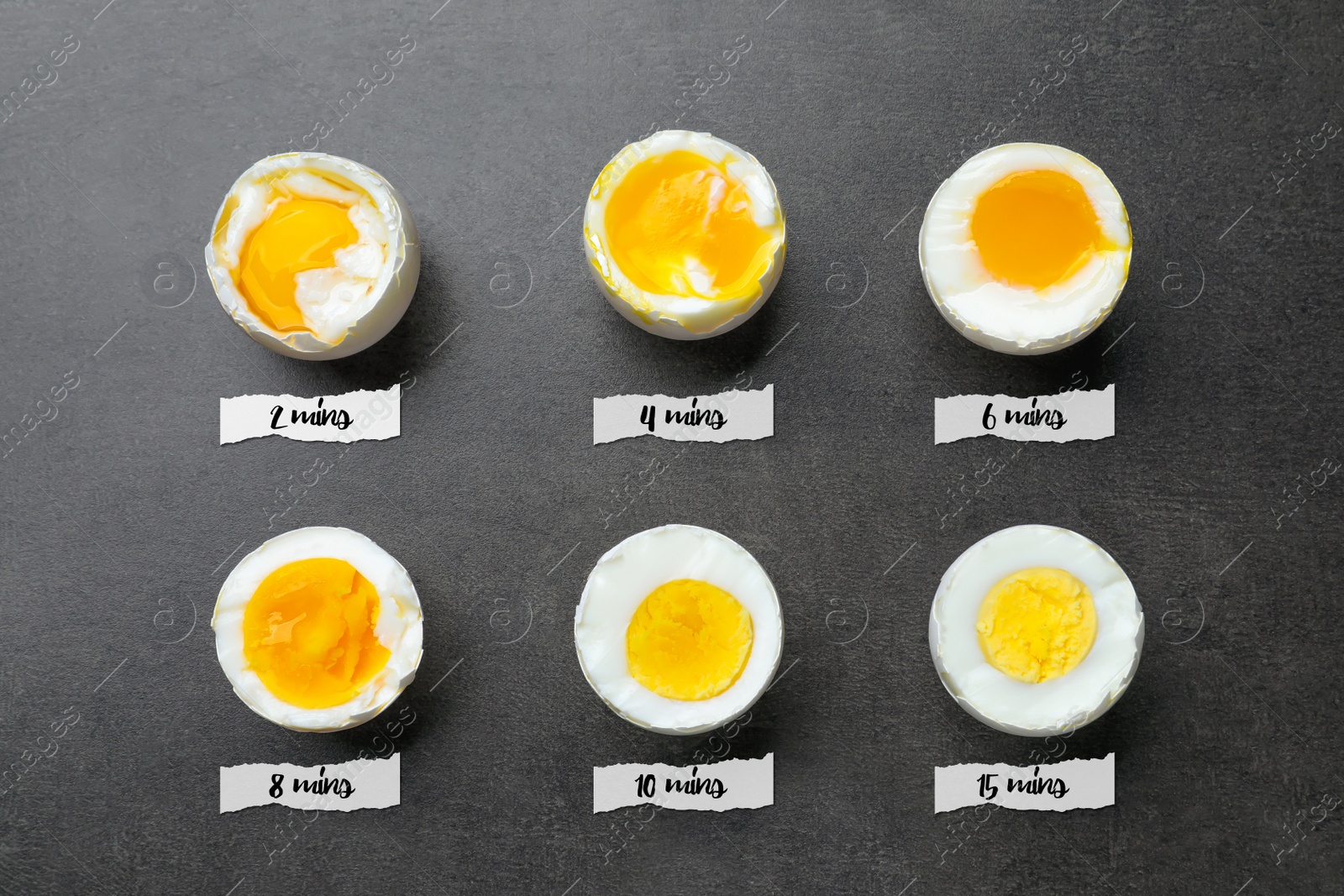 Image of Different readiness stages of boiled chicken eggs on dark grey table, flat lay