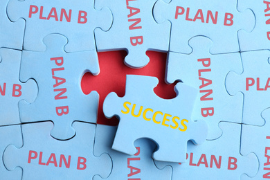 Image of Light blue puzzle with phrases PLAN B and SUCCESS on red background, top view