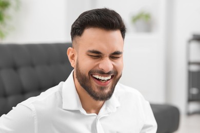 Portrait of handsome young man laughing in office