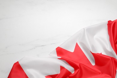 Flag of Canada on white marble background, top view. Space for text