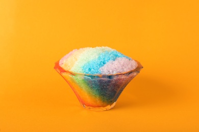 Photo of Rainbow shaving ice in glass dessert bowl on orange background