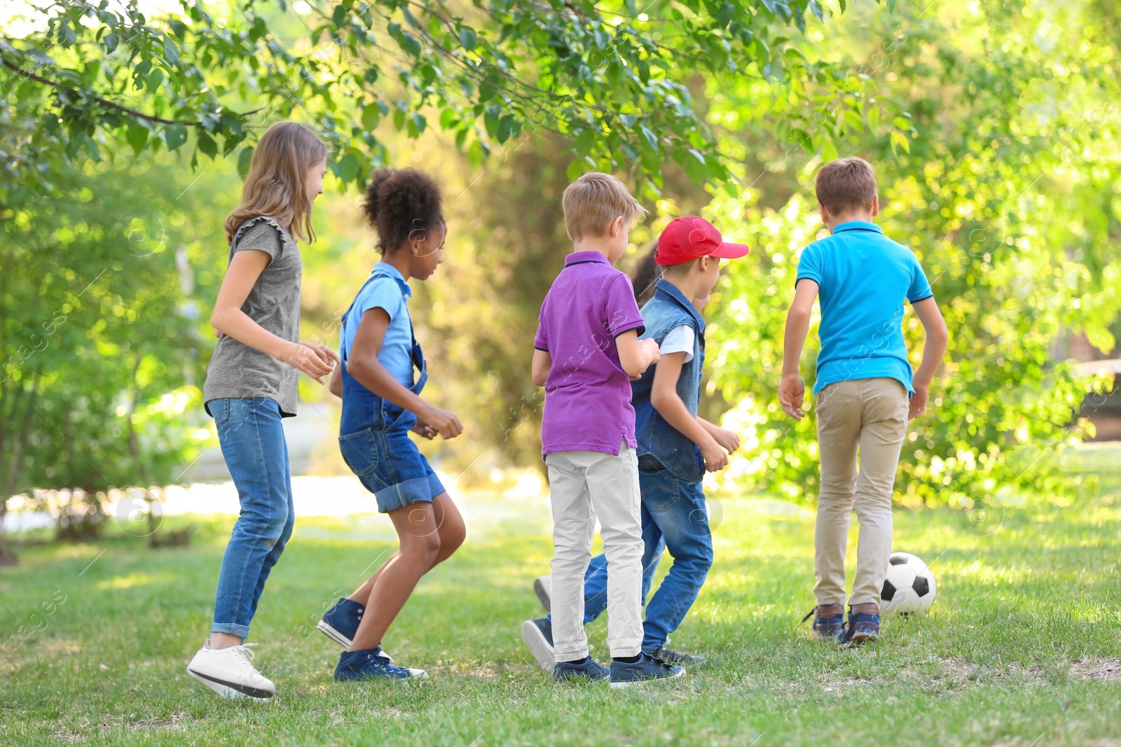 Photo of Cute little children playing with ball outdoors on sunny day