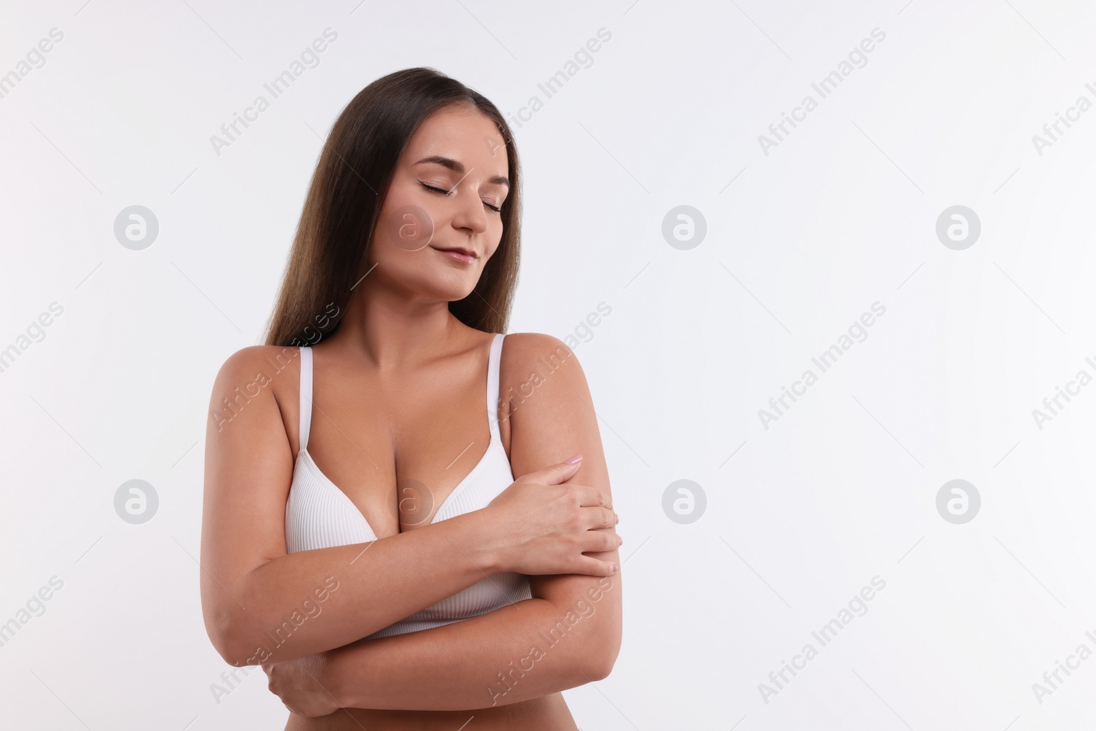 Photo of Portrait of young woman with beautiful breast on white background. Space for text