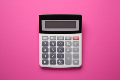 Photo of Calculator on pink background, top view. Office stationery